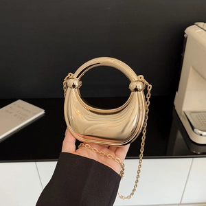 Golden crescent acrylic mirror evening bag with large round handle and chain strap
