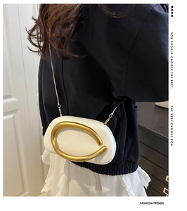 Detailed view of white semi-circular PU crossbody bag with large matte gold metal accent