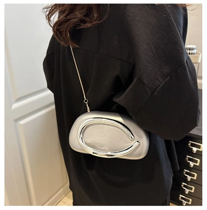 Detailed view of silver acrylic evening bag with metal ring handle and chain strap
