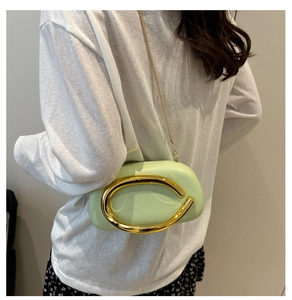Detail of light green round acrylic evening bag with gold ring handle and chain strap
