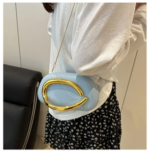 Detail of light blue acrylic evening bag with gold oval handle and chain shoulder strap