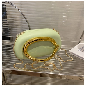 Close-up of mint green acrylic clutch with gold C-shaped metal handle and chain strap