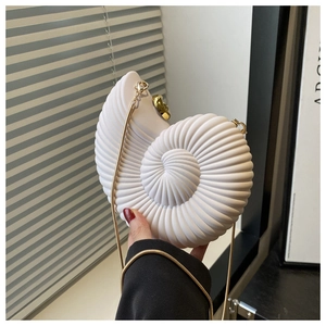 Close-up of white conch shell shaped clutch bag with golden chain and round metal lock