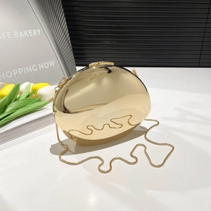 Macro view of polished gold mirror finish on an oval acrylic evening clutch with metal chain
