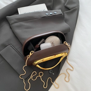 Detail of dark brown evening bag interior showing capacity for makeup and accessories