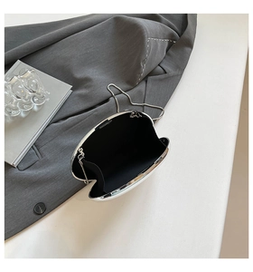 Silver oval shell clutch bag with internal black lining and sleek metal chain strap