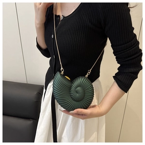Detail view of conch-shaped crossbody bag with acrylic chain worn by a model
