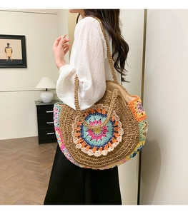 Détail du motif mandala en crochet coloré sur un sac de plage en paille tressée