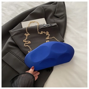 Detail of Klein blue acrylic evening bag with wave texture and gold metal clasp