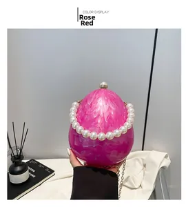 Détail du sac oeuf en acrylique marbre rose avec poignée en perles et chaîne dorée