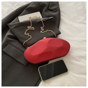 Modern red irregular stone evening clutch bag with circular indentations and gold chain