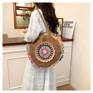 Détail de grand sac cabas rond en paille avec motif floral mandala au crochet coloré