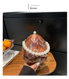 Détail du sac oeuf en acrylique marbre brun avec poignée perle et chaîne dorée
