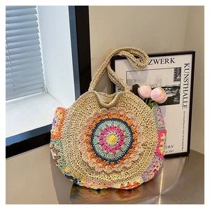 Gros plan détaillé du motif mandala crocheté sur un sac de plage rond en paille tissée