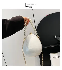 Sac de soirée blanc nacré en forme d'œuf avec grande anse en perles et chaîne dorée