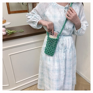 Détail du sac à téléphone en crochet vert avec design évidé et longue bandoulière