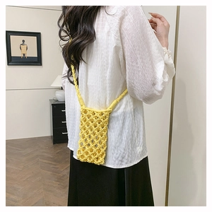 Détail d'un sac de téléphone jaune en crochet avec texture tissée ajourée