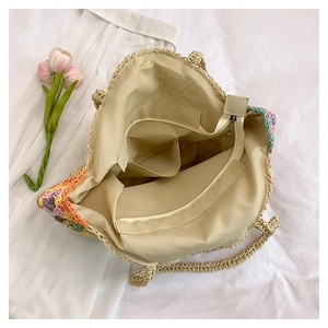 Vue intérieure du sac en paille avec doublure beige, fermeture éclair et poches fentes
