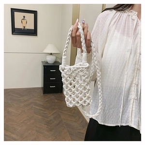 Détail d'un petit sac bandoulière blanc en coton tressé ajouré avec sangle robuste