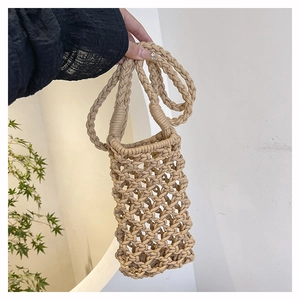 Gros plan d'un mini sac bandoulière en coton tressé beige avec texture évidée