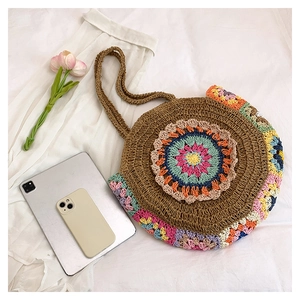 Détail du sac bohème en paille avec motif mandala au crochet coloré et doubles poignées