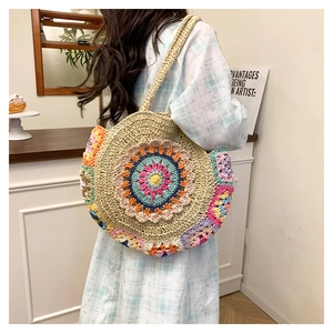 Détails de motifs floraux au crochet sur un sac rond bohème en paille tressée