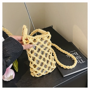 Gros plan sur le sac de téléphone en coton tissé jaune avec motif creux géométrique