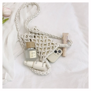 Détail d'un sac de téléphone en coton tissé creux avec motif blé et bandoulière