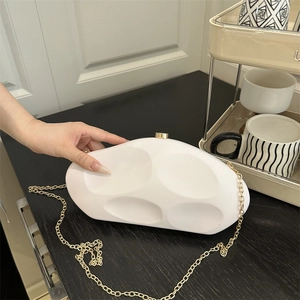 Fashionable white irregular pebble clutch bag with gold sphere clasp and chain strap