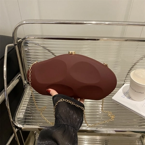 Artistic burgundy irregular stone-shaped acrylic clutch with gold chain and matte finish