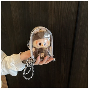 Detail of transparent PVC mini pouch showing Labubu plush toy inside with checkerboard strap