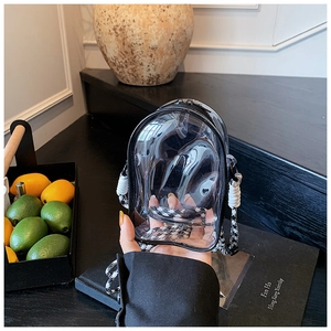 Close-up of a clear PVC jelly bag with a stylish black and white houndstooth strap