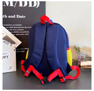 Détail du dos d'un sac à dos enfant avec bretelles rouges et boucle de poitrine bleue