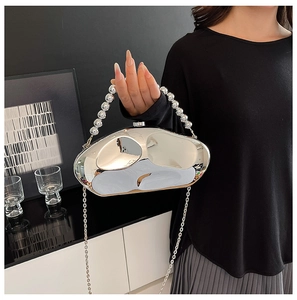 Close-up of pebble-shaped silver evening bag with beaded handle and chain strap