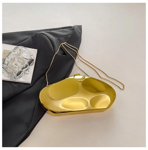 Detailed view of the irregular geometric gold evening clutch with its sleek metal chain strap