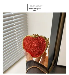 Detail view of a heart-shaped mini clutch with red sequins and a fine gold chain strap