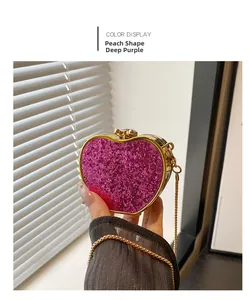 Detail of a purple glitter heart-shaped clutch bag with gold chain and gem closure
