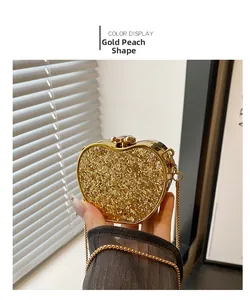 Detail of a heart-shaped gold glitter evening bag with chain and metal ball clasp