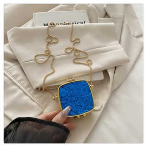 Close-up of klein blue mini acrylic chain bag with gold hardware and grain texture