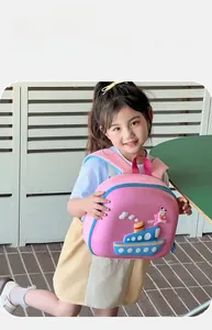 Detailed close-up of pink 3D cartoon ship EVA backpack with blue zipper on young girl