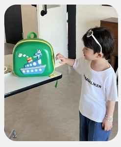 Close-up of green EVA hardshell kids backpack featuring 3D cartoon ship and cloud detail