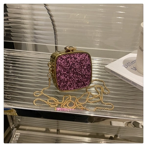 Detail of purple glitter acrylic mini evening bag with gold chain and metal frame