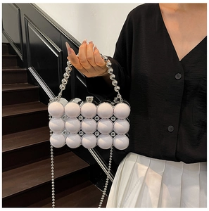 Detail of beaded acrylic evening bag with spherical 3D decor and silver chain strap