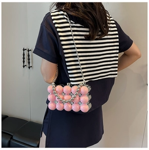 Pink bubble acrylic evening bag with silver bead chain strap shown on a model
