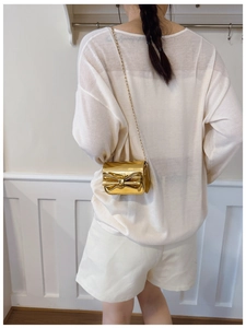 Détail du mini sac bandoulière doré avec nœud papillon et fine chaîne métallique