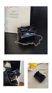 Détail du mini sac en cuir verni noir brillant avec grand nœud et chaîne dorée