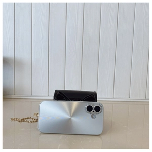 Détail d'une coque argentée à texture rayonnante avec un sac à chaîne nœud papillon noir