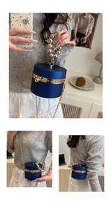 Macro detail of navy cylindrical evening bag with pearl handle and chain strap
