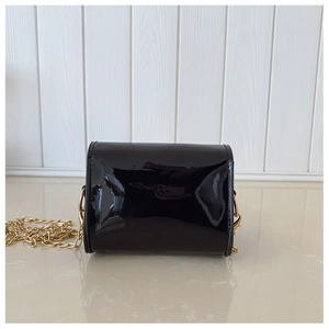 Détail du mini sac en cuir verni noir brillant avec bandoulière en chaîne dorée claire