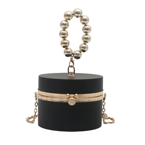 Elegant black cylindrical acrylic clutch bag with gold bead handle and metal chain strap